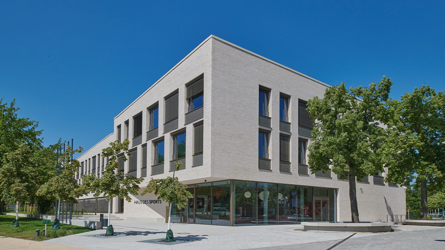 Außenansicht des Haus des Sports beim Landessportbund Potsdam mit heller Fassadenbekleidung, großen Glasflächen, 3D-Optik-Platten und modernem Fassadensystem.