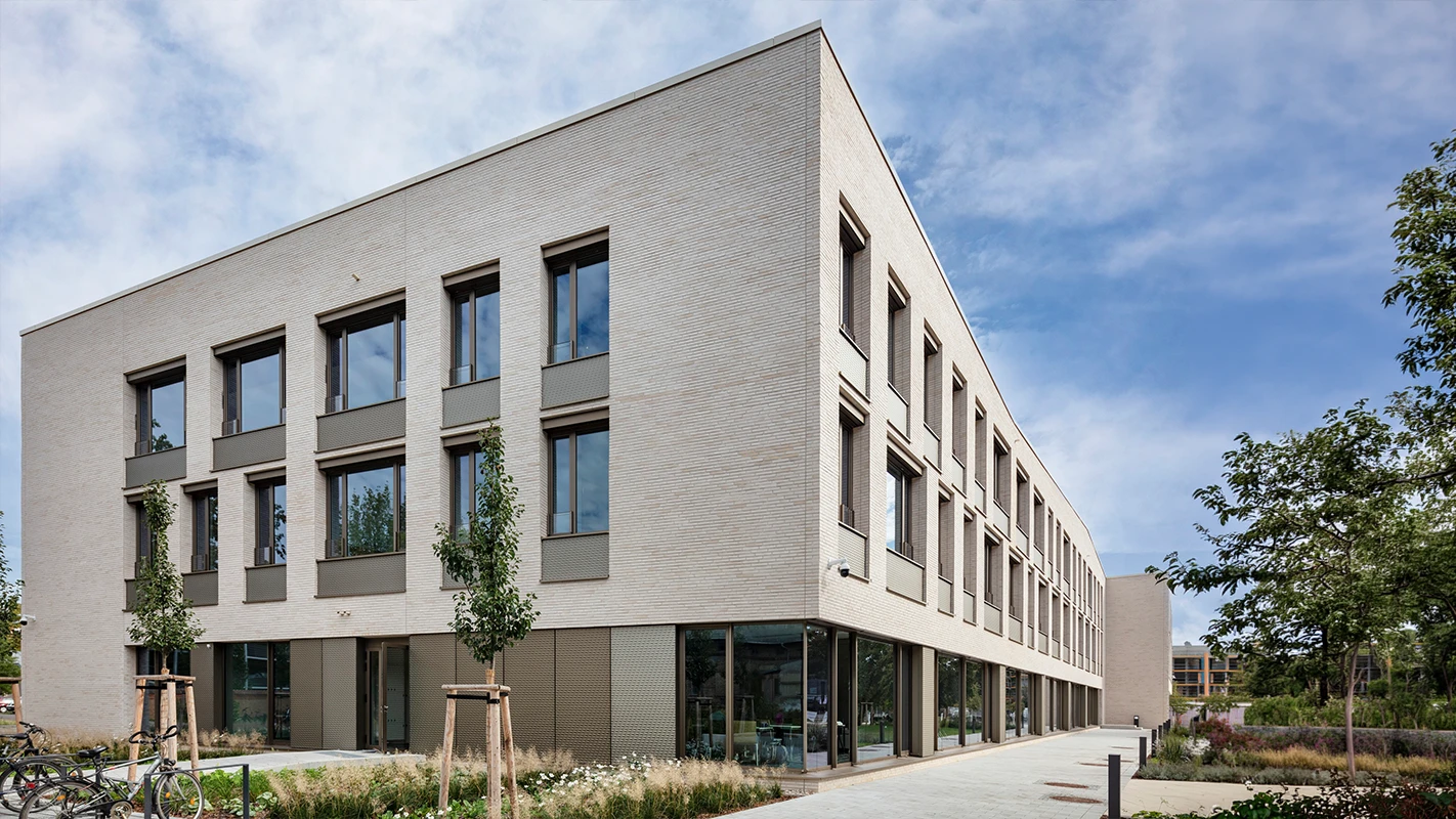 Modernes Gebäude des Landessportbundes Potsdam mit heller Fassadenbekleidung, 3D-Optik-Platten, großen Fenstern und begrüntem Außenbereich als hochwertiges Fassadensystem.