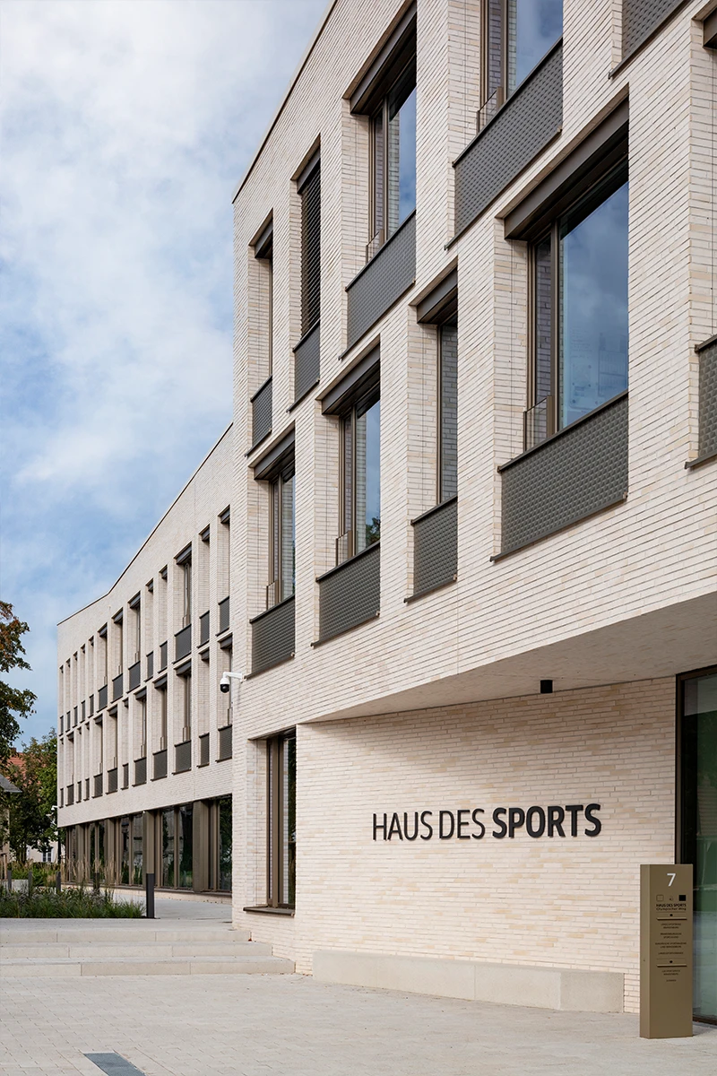 Eingangsbereich des Landessportbundes Potsdam mit heller Klinkerriemchen-Fassade, 3D-Optik-Platten, modernen Fenstern und repräsentativer Fassadengestaltung.